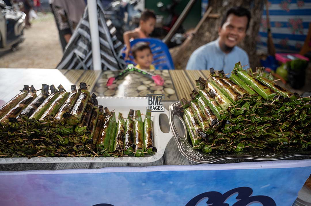Pedagang makanan khas Lalampa menunggui pembeli di Pasar Ramadhan di Palu, Sulawesi Tengah, Selasa (12/3/2024). Lalampa adalah salah satu penganan khas yang banyak dijajakan pedagang di bulan Ramadhan di wilayah itu, terbuat dari beras ketan putih dicampur santan dan dibungkus daun pisang lalu dipanggang di atas bara api. bmzIMAGES/Basri Marzuki
