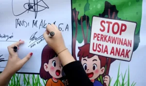 Seorang remaja membubuhkan tandatangan pada deklarasi pencegahan perkawinan usia anak di Palu, Minggu (13/7/2025). (bmzIMAGES/Basri Marzuki)