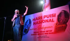 Seniman Arifin Sunusi mendeklamasikan puisinya dalam perayaan Hari Pusi Nasional di depan Kantor DPRD Sulteng, Sabtu (2/8/2025) malam. (©bmzIMAGES/basri Marzuki)